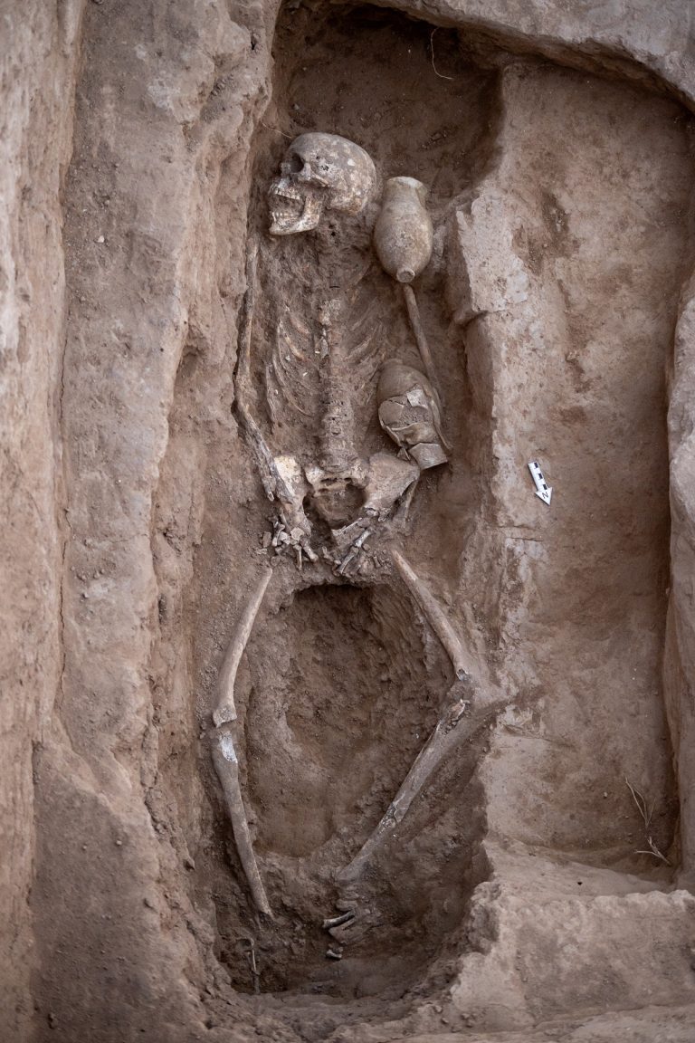 Scheletro con corredo funerario posto all’interno della stanza dedicata al culto dei defunti / Skeleton with funerary goods placed inside the room dedicated to the cult of the dead