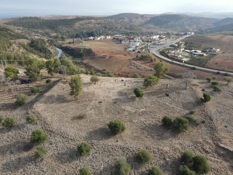 L’area del sito di Oued Beht delimitata dalle strutture difensive, con il villaggio di Aït Siberne sullo sfondo (foto: A. Garcia-Molsosa e T. Wilkinson, Archivio OBAP / The Oued Beht area enclosed by the defensive structures, with the village of Aït Siberne in the background (photo: A. Garcia-Molsosa and T. Wilkinson, OBAP Archive)